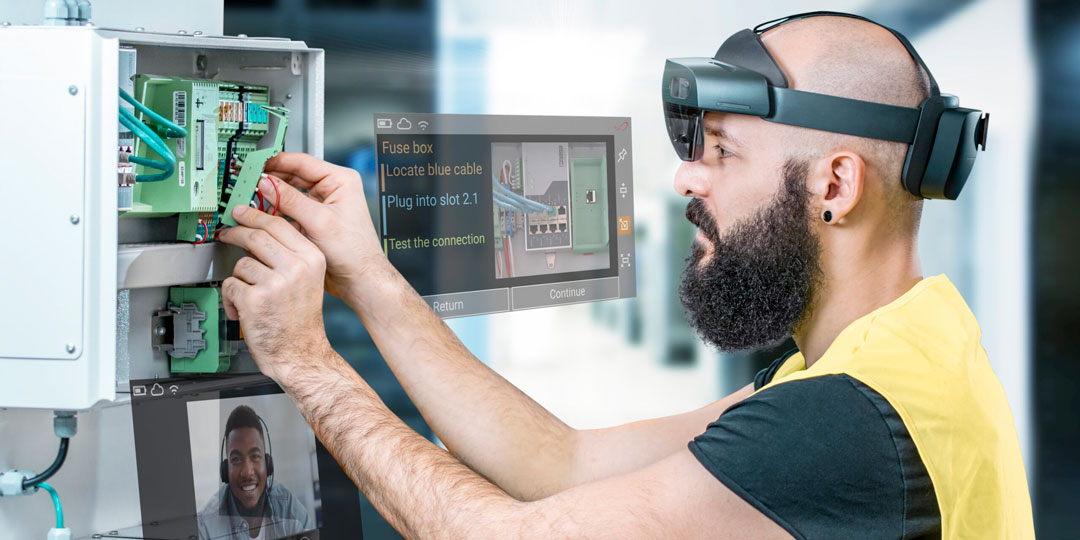 Techniker mit HoloLens 2 erhält visuelle Anleitungen über die TeamViewer Frontline Hologramme und arbeitet an einem Schaltschrank